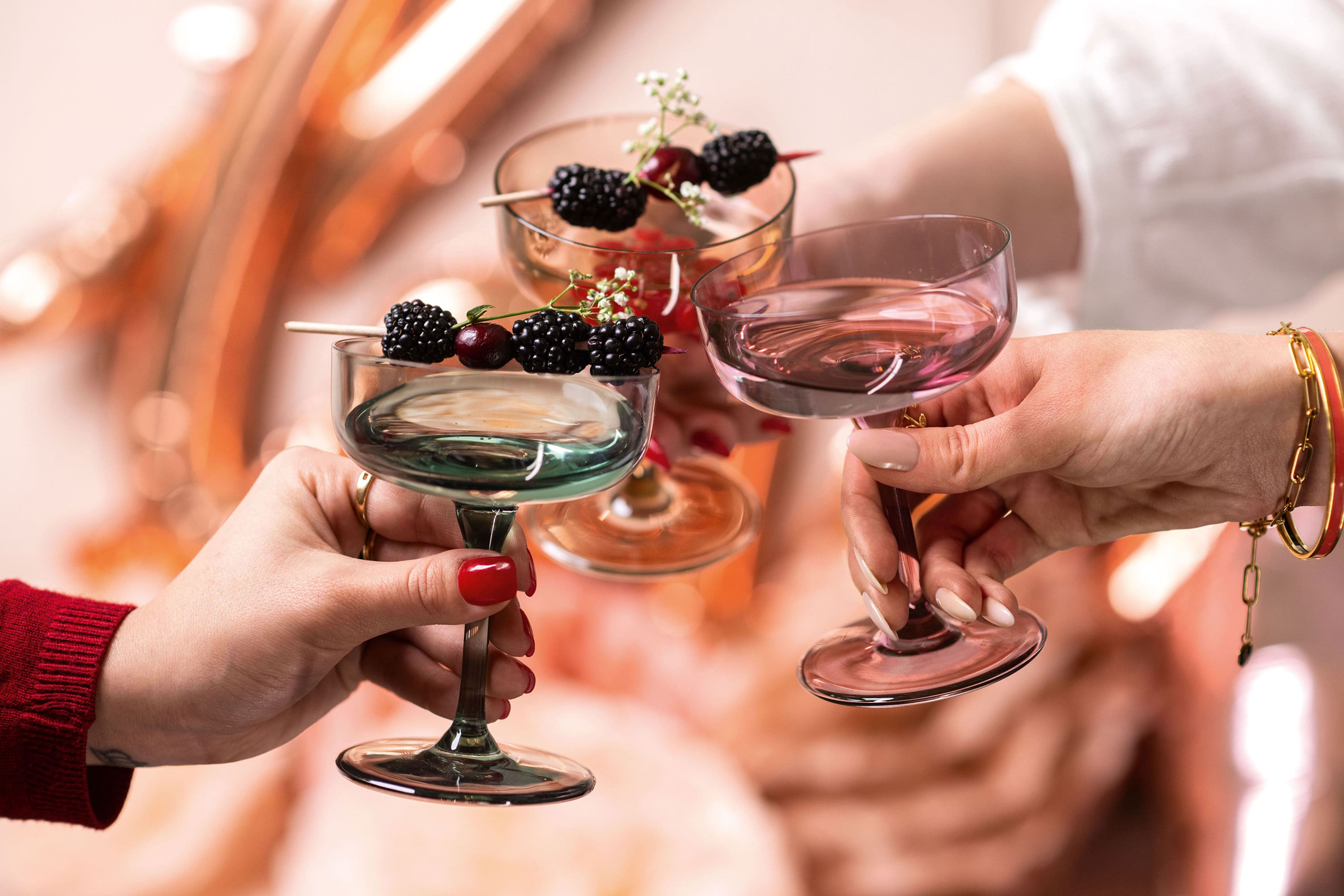 Een groepje mensen met like. champagneglazen met bessen erin.