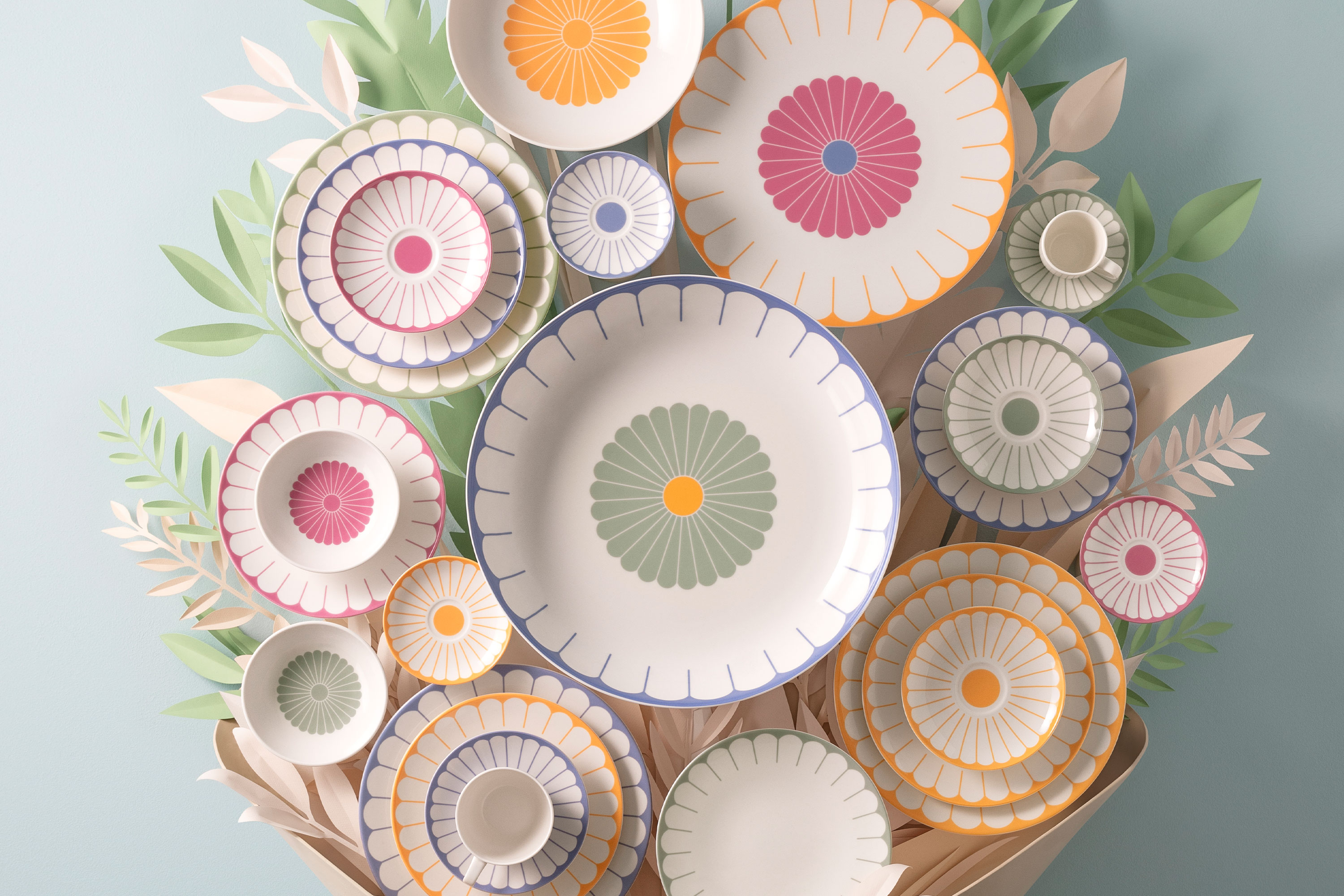 A collection of decorative plates from the Fleur collection A collection of decorative plates from the Fleur collection with colourful patterns arranged on a wall and surrounded by paper leaf decorations.
