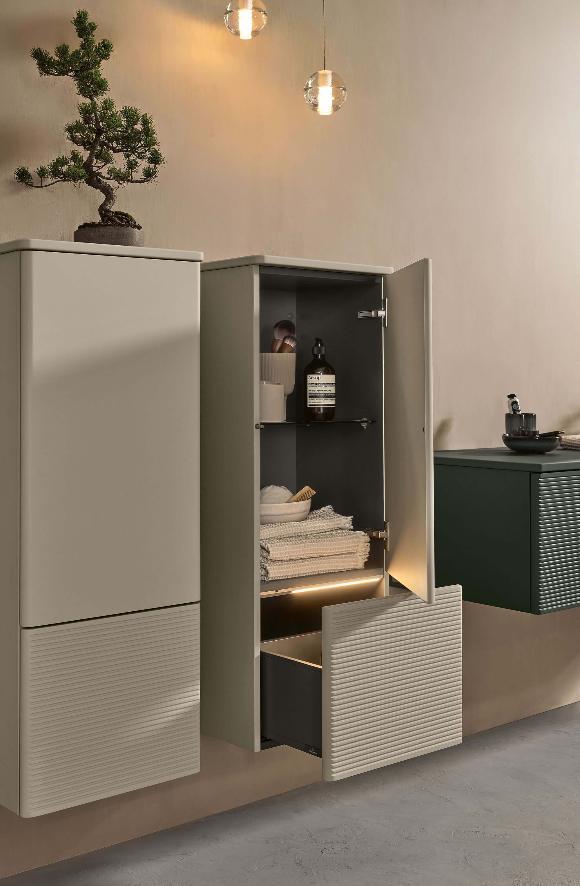 Un meuble suspendu Antao gris avec une porte ouverte et une plante
