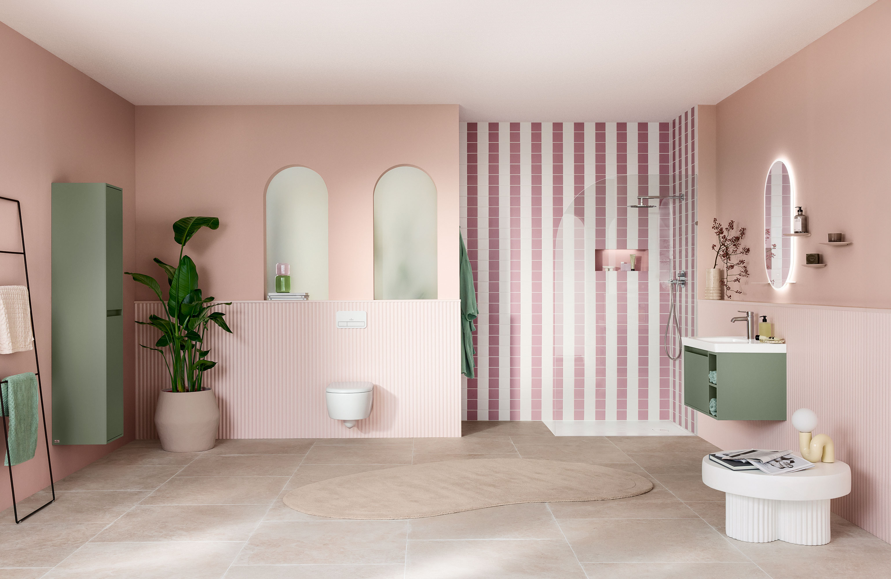 Modernes Badezimmer mit rosa Wänden, gestreiftem Duschbereich, grünen Akzenten, großen Spiegeln und einer Topfpflanze.