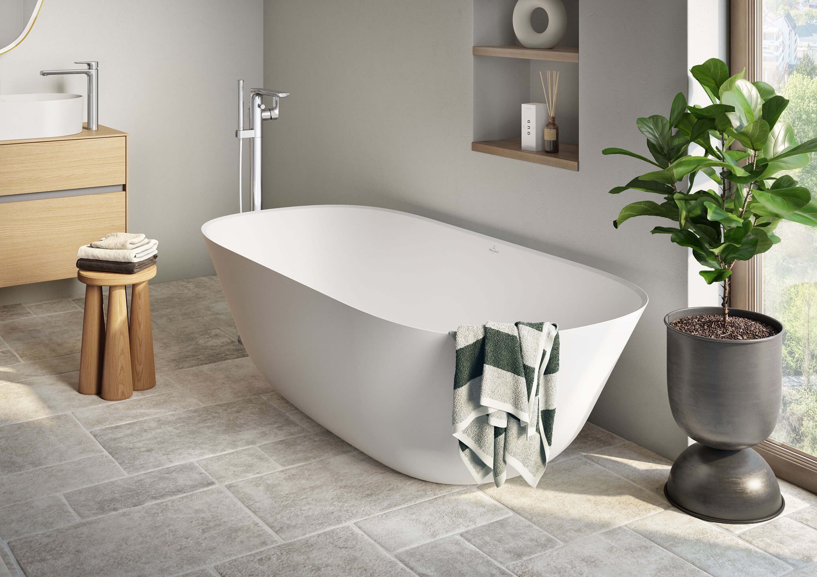 A modern bathroom with a white Theano bath by Villeroy & Boch and a plant.