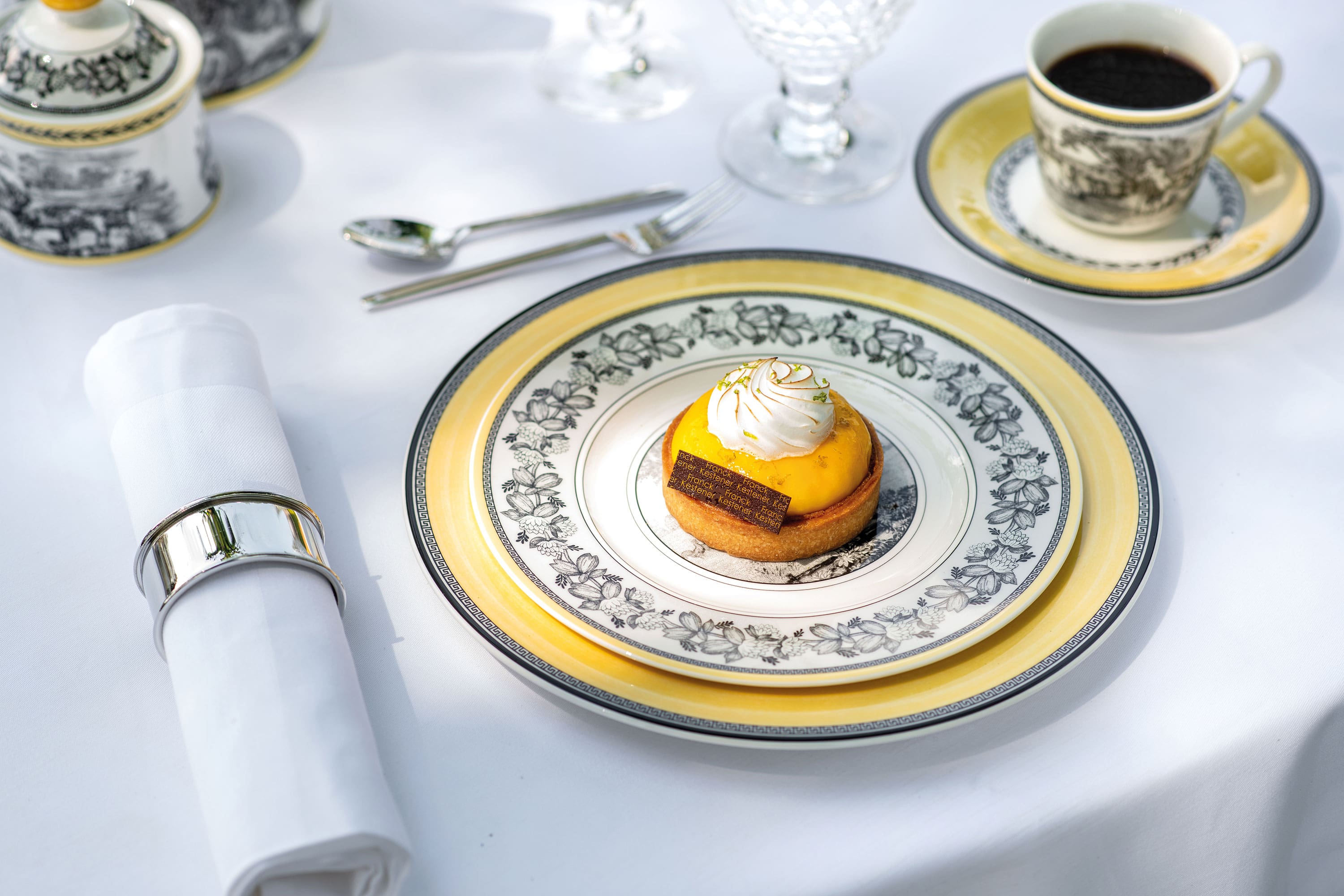 A small dessert with yellow topping and whipped cream on a decorative plate from the Audun collection by Villeroy & Boch. 