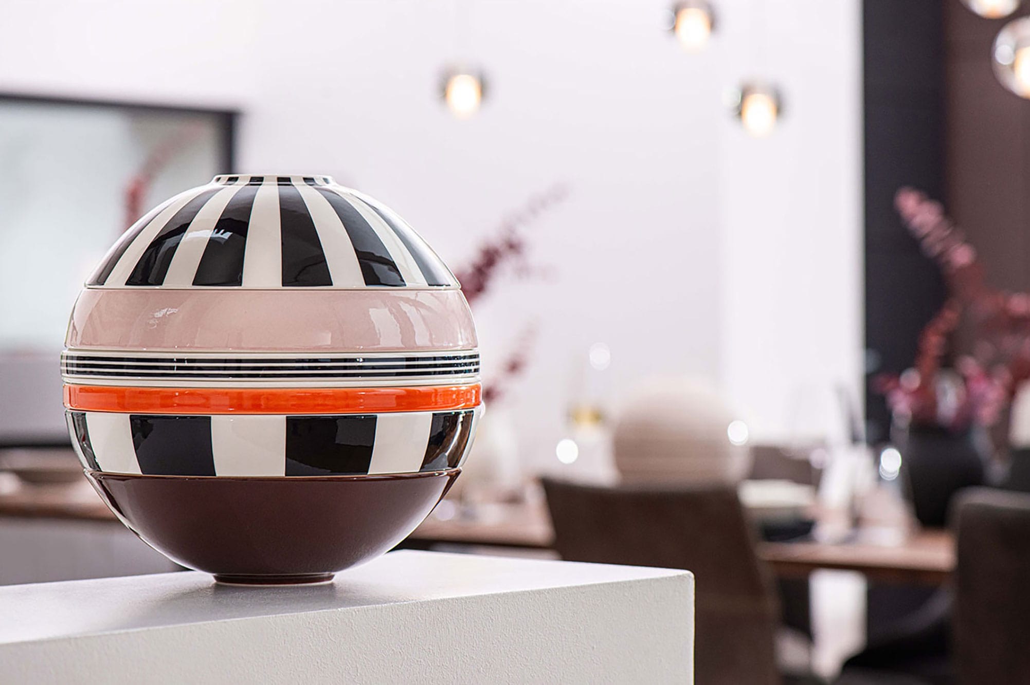 A Villeroy & Boch striped La Boule Memphis on a table in a dining room.