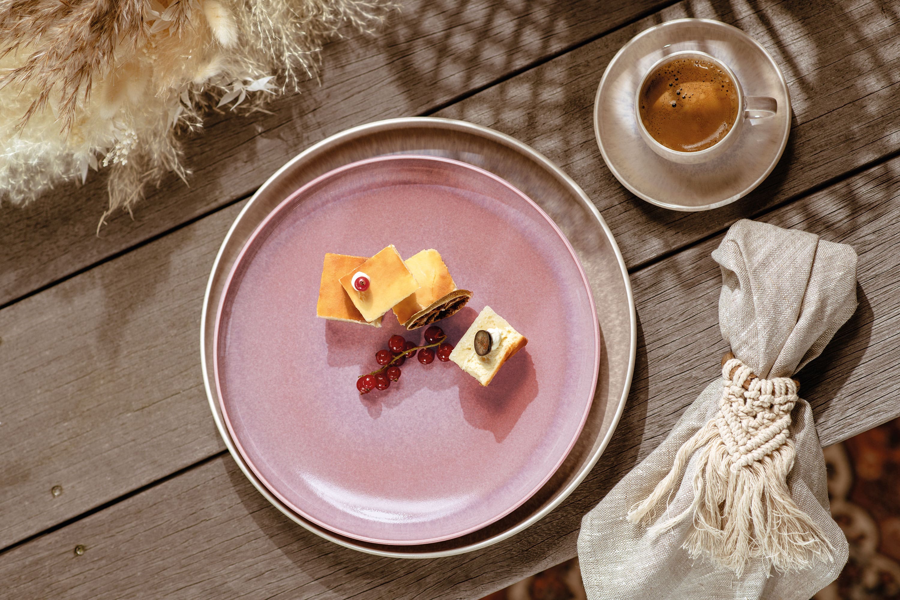 A pink like. by Villeroy & Boch Perlemor breakfast plate with a piece of cheese and a cup of coffee.