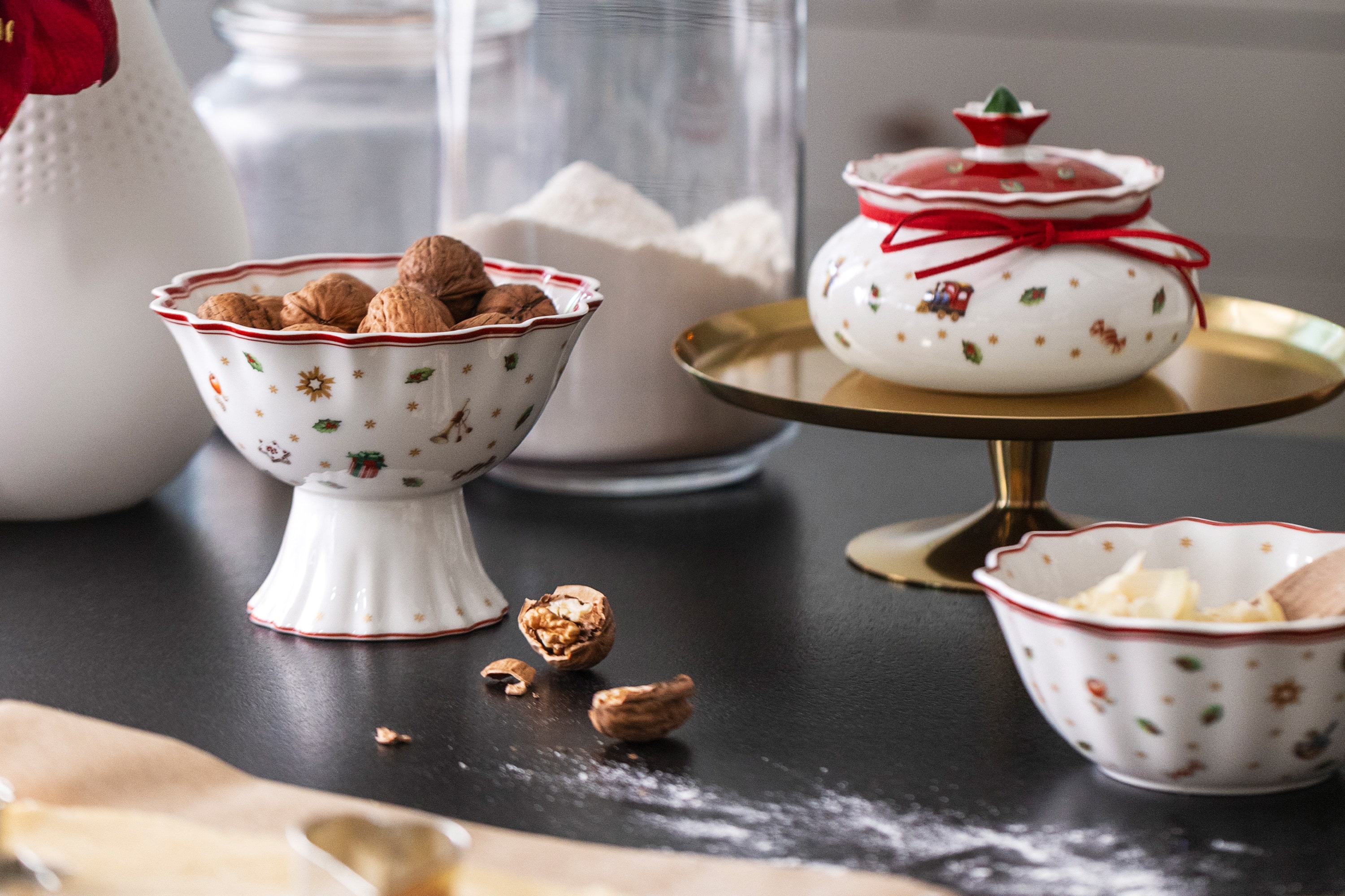 Toy's Delight bowl with walnuts Villeroy & Boch "Toy's Delight" ceramic bowls filled with walnuts and butter on a dark countertop, surrounded by sprinkled flour and cracked walnuts.