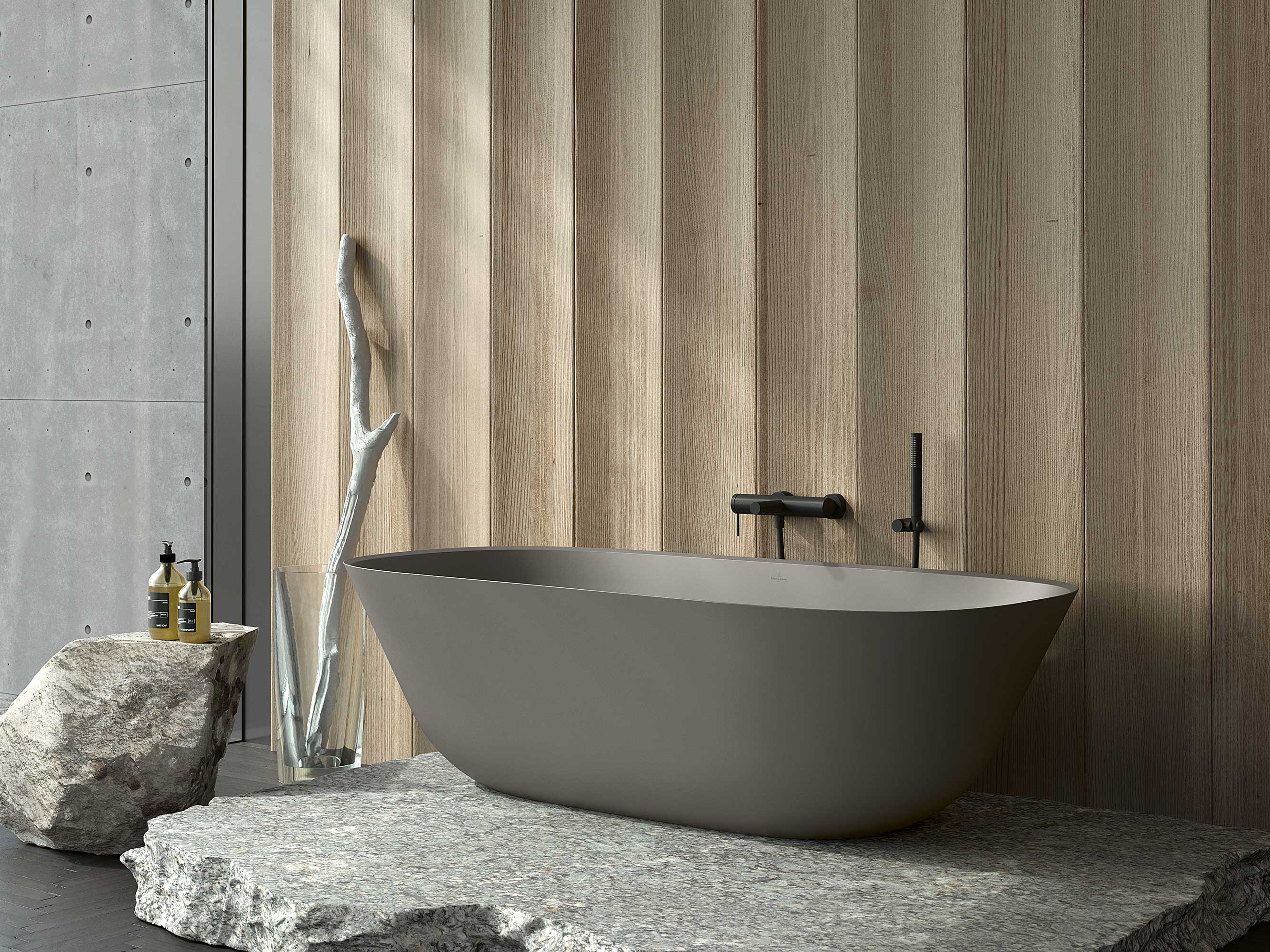 Une baignoire en îlot grise Theano de Villeroy & Boch Une salle de bains minimaliste avec une baignoire Theano grise sur pied de Villeroy & Boch sur une plateforme en pierre.